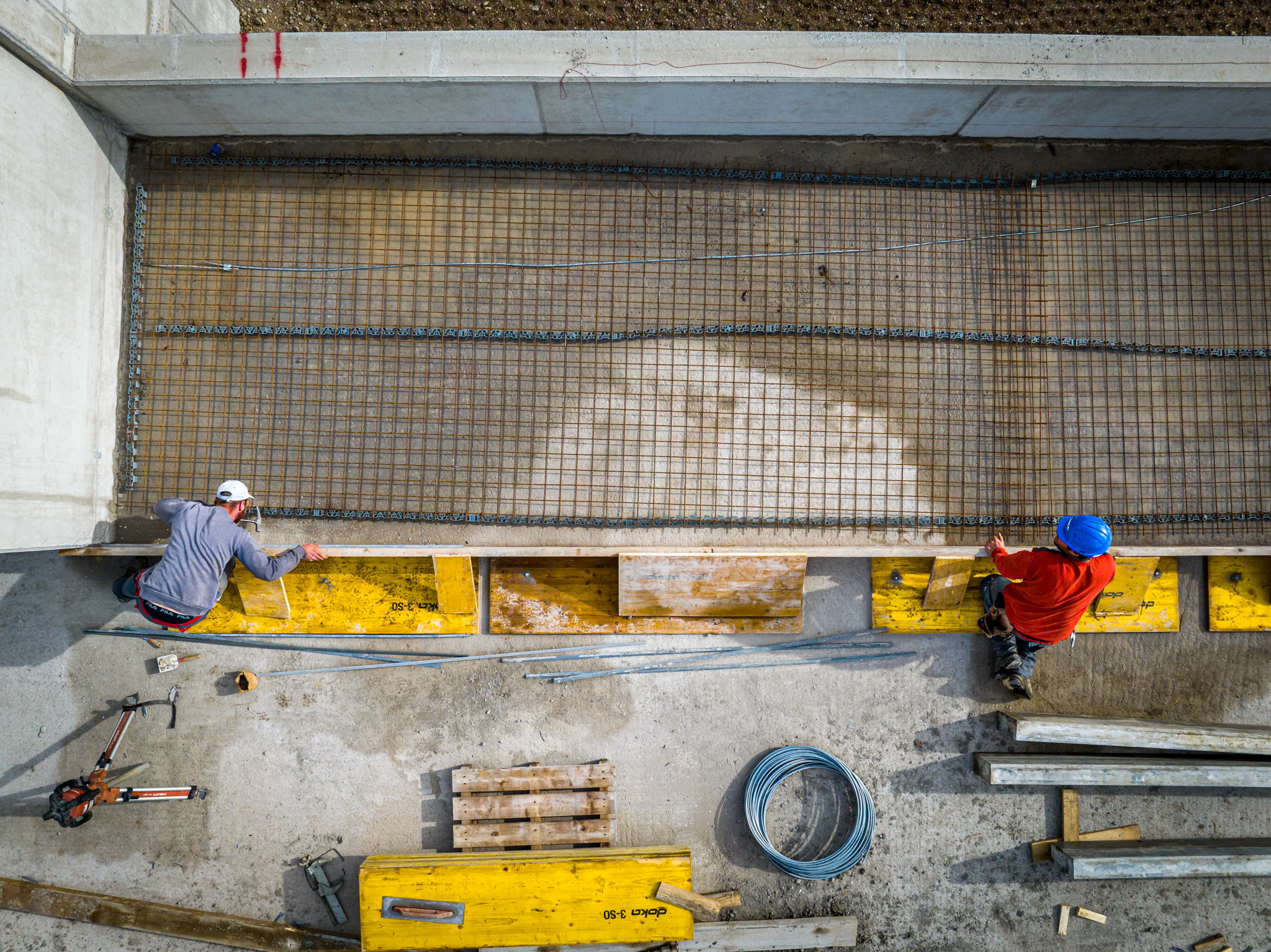 Doll Baustelle Drohne Vogelperspektive zwei Mitarbeiter Beton giessen A WEB