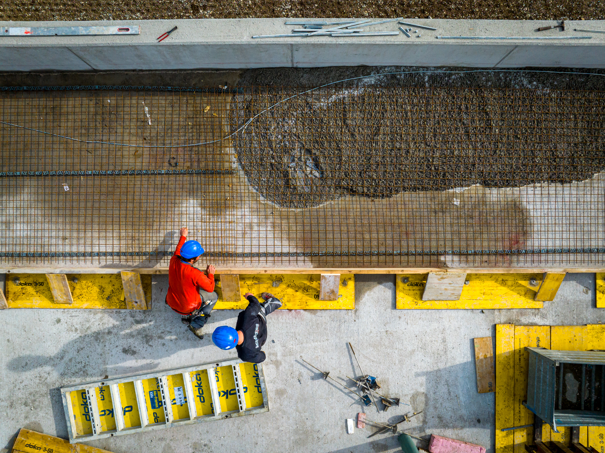 Doll Baustelle Drohne Vogelperspektive zwei Mitarbeiter Beton giessen WEB