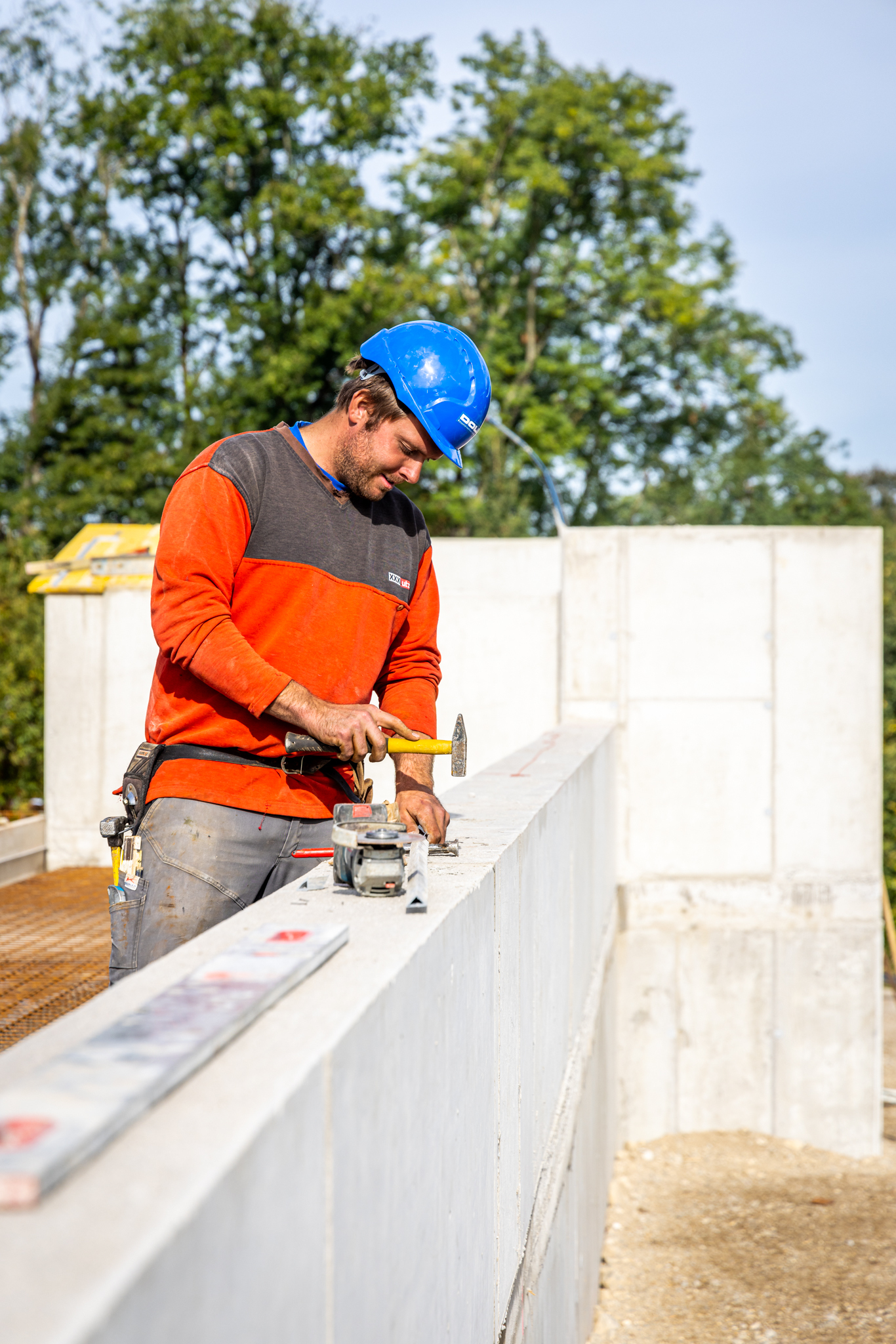 Doll Baustelle Mitarbeiter mit Hammer bei Mauer WEB